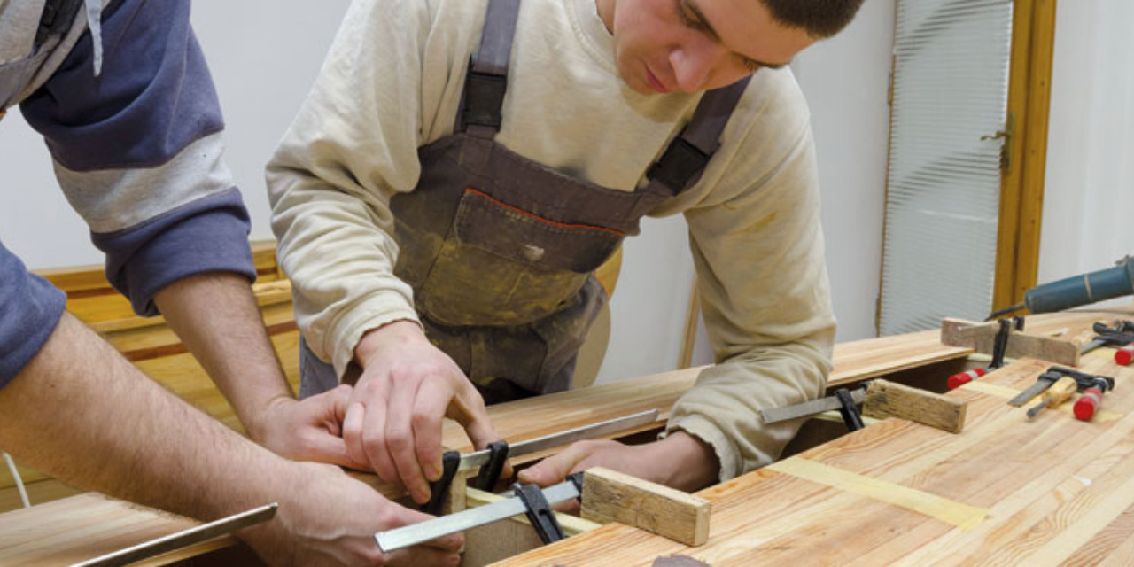 Apprenti travaillant le bois avec son formateur